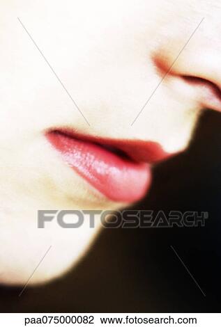 Stock Image - Woman wearing red lipstick, close up of mouth. Fotosearch
