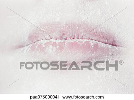 Stock Image - Woman wearing white face powder, close up of mouth.. Fotosearch
