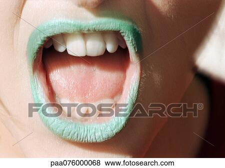 Stock Photo - Close up of woman's mouth open with green lipstick.. Fotosearch