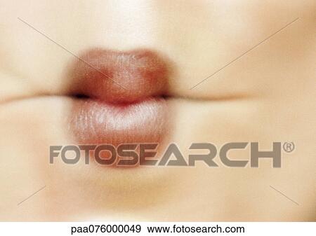 Stock Photo - Close up of woman's mouth sucking in cheeks, blurred. Fotosearch