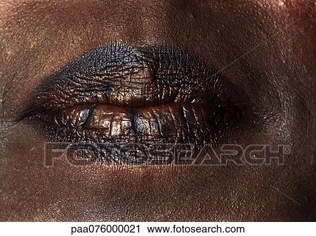 Stock Image - Close up of woman's mouth with dark lipstick. Fotosearch