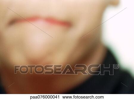 Stock Image - Close up of woman's mouth with pursed lips, blurry.. Fotosearch