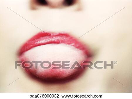 Stock Image - Close up of woman's mouth with tongue sticking out, blurry.. Fotosearch