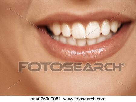 Stock Image - Lower section of woman's face, toothy smile, extreme close-up. Fotosearch