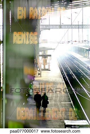 Couple walking on train platform, information sign superimposed View Large Photo Image Stock Photo - Couple walking on train platform, information sign superimposed. Fotosearch