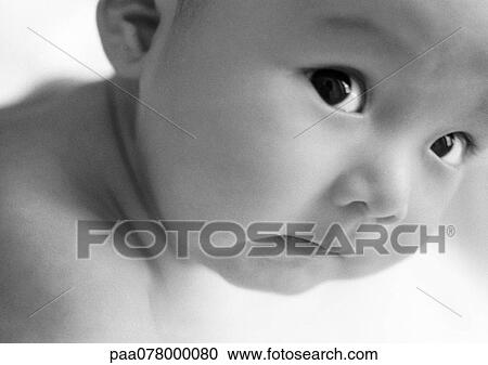 Stock Image - Baby looking at camera, close-up, B&W.. Fotosearch