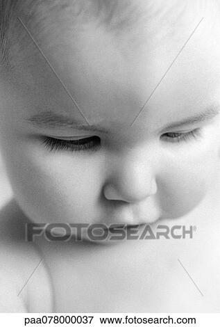 Stock Photo - Baby looking down, close-up, B&W.. Fotosearch