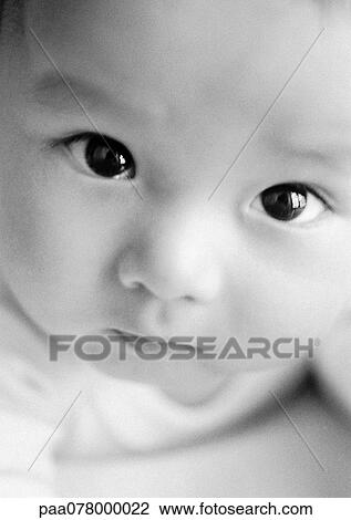 Stock Image - Baby looking up at camera, close-up, B&W.. Fotosearch