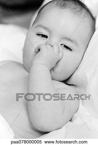 Stock Photography - Baby lying down, sucking thumb, B&W.. Fotosearch