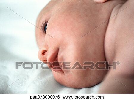 Stock Photograph - Baby lying on blankets, view from below, close-up.. Fotosearch