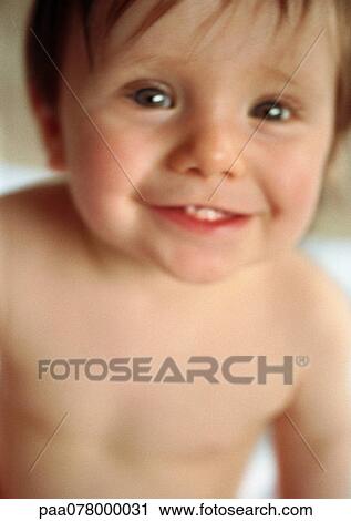 Stock Image - Baby smiling at camera, blurred. Fotosearch