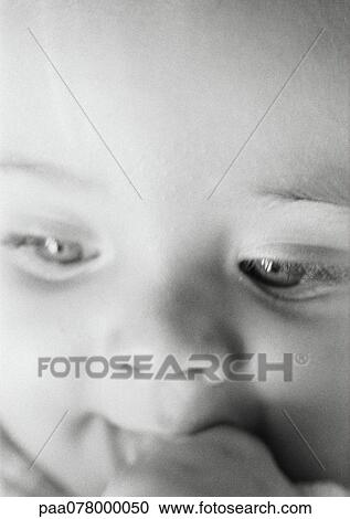Baby with hand to mouth, looking down, close-up, B&W. View Large Photo Image Stock Image - Baby with hand to mouth, looking down, close-up, B&W.. Fotosearch