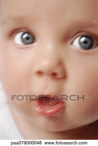 Stock Photo - Baby's face, mouth open, looking at camera, close-up, blurred.. Fotosearch