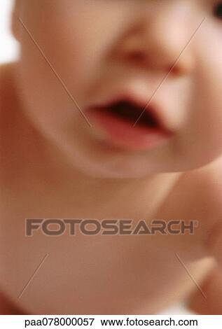 Stock Photo - Partial view of baby's face with mouth open, blurred, close-up.. Fotosearch