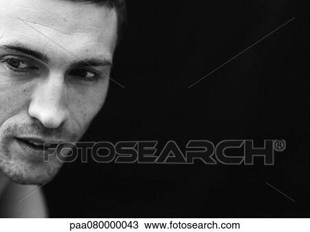 Stock Image - Man looking away, close-up, black and white.. Fotosearch