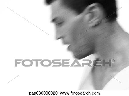 Stock Image - Man looking down, side view, close-up, blurred, black and white.. Fotosearch