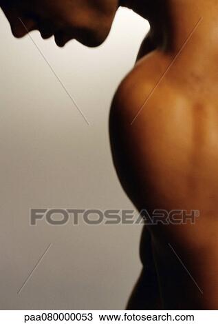 Stock Image - Man looking down, side view, cropped.. Fotosearch