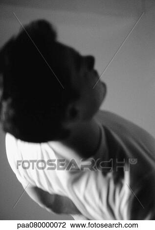 Stock Image - Man standing, high angle view, black and white.. Fotosearch