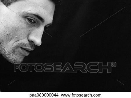 Picture - Man tilting head down, side view, close-up, black and white.. Fotosearch