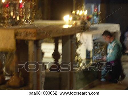 Stock Image - Israel, Jerusalem, man kneeling at altar, blurry.. Fotosearch