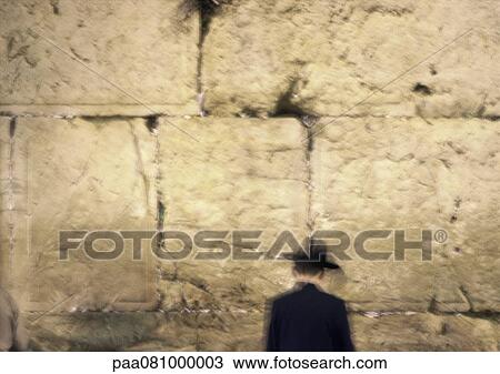 Stock Image - Israel, Jerusalem, man standing in front of Wailing Wall. Fotosearch