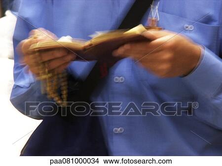 Picture - Israel, Jerusalem, man's hands holding prayer book and rosary, close-up. Fotosearch