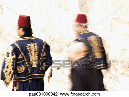 Stock Image - Israel, Jerusalem, two men in decorative outfits, blurry.. Fotosearch