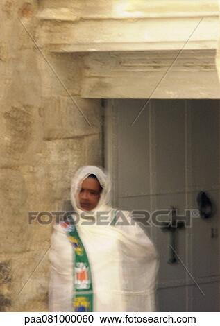 Stock Image - Israel, Jerusalem, woman in front of church doorway, blurry.. Fotosearch