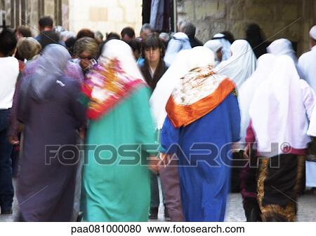 Stock Image - Israel, Jerusalem, women wearing headscarves walking in crowded street, rear view. Fotosearch