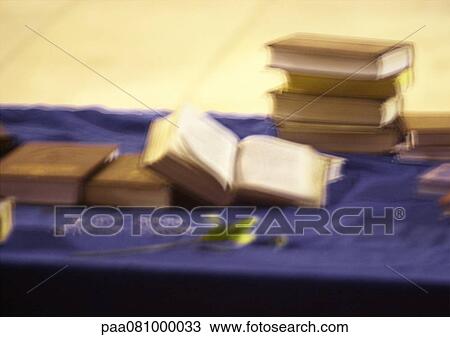 Stock Image - Stack of religious books with olive branch, blurry.. Fotosearch