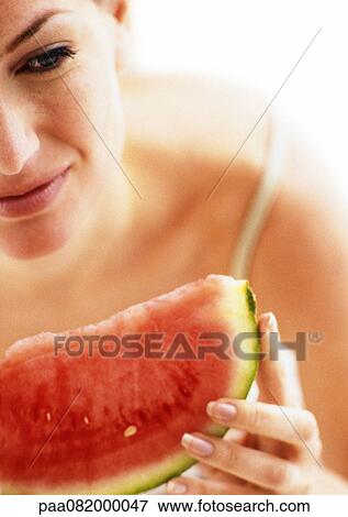 Stock Photo - Partial view of woman holding slice of watermelon, close-up. Fotosearch