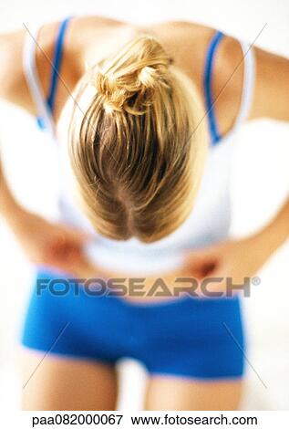 Woman bending forward, looking down at waist. View Large Photo Image Stock Photo - Woman bending forward, looking down at waist.. Fotosearch