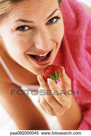 Woman eating strawberry, low angle view, close-up View Large Photo Image Stock Photography - Woman eating strawberry, low angle view, close-up. Fotosearch