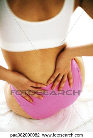 Woman holding lower back, rear view. View Large Photo Image Stock Image - Woman holding lower back, rear view.. Fotosearch