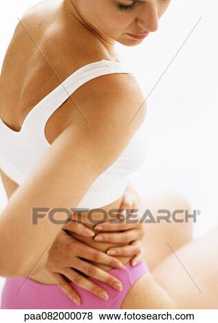 Woman in underwear holding side, looking down, close-up View Large Photo Image Stock Photo - Woman in underwear holding side, looking down, close-up. Fotosearch