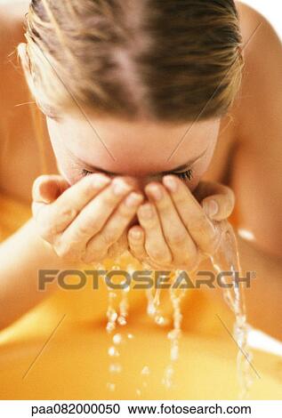 Woman leaning forward, cupping water to face, close-up View Large Photo Image Stock Image - Woman leaning forward, cupping water to face, close-up. Fotosearch