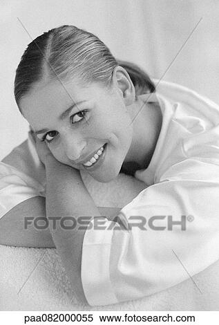 Woman leaning head on arms, smiling at camera, B&W. View Large Photo Image Stock Photography - Woman leaning head on arms, smiling at camera, B&W.. Fotosearch