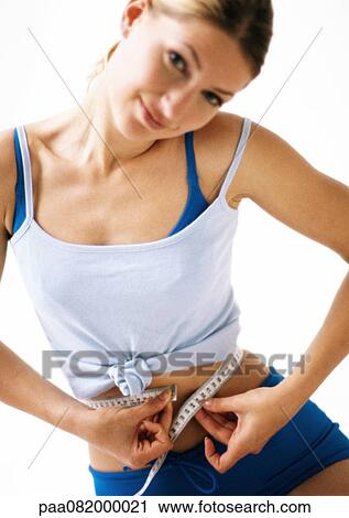 Woman measuring waist with measuring tape, close-up View Large Photo Image Stock Image - Woman measuring waist with measuring tape, close-up. Fotosearch