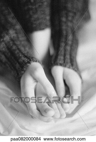 Picture - Woman sitting, close-up of hands holding foot, B&W.. Fotosearch