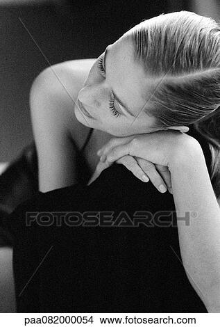 Picture - Woman sitting, leaning head on hands, B&W.. Fotosearch