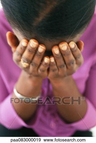 Stock Photo - Close up of woman covering face, high angle view. Fotosearch