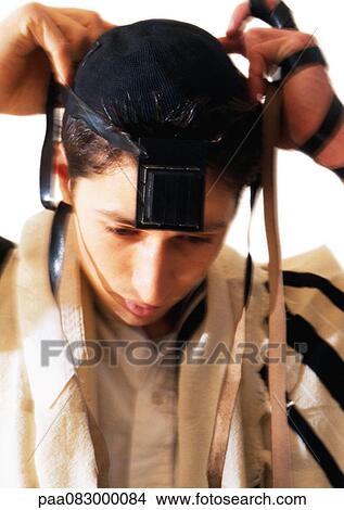 Jewish man putting on Tefillin, close-up View Large Photo Image Picture - Jewish man putting on Tefillin, close-up. Fotosearch