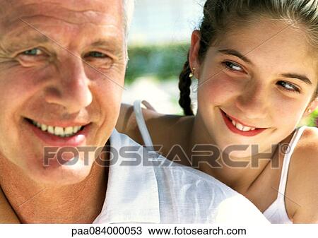 Stock Image - Girl looking at mature man, close up.. Fotosearch
