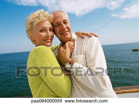 Stock Photo - Mature couple embracing on boat deck.. Fotosearch