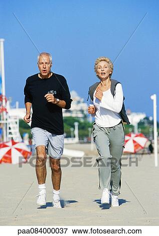 Mature couple jogging on beach, front view, full length View Large Photo Image Stock Photo - Mature couple jogging on beach, front view, full length. Fotosearch