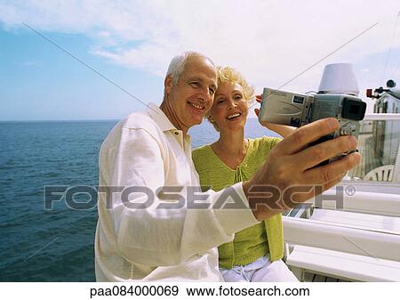 Mature couple making video of themselves on boat. View Large Photo Image Stock Photo - Mature couple making video of themselves on boat.. Fotosearch