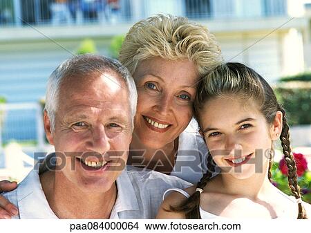 Picture - Mature couple sitting with girl, portrait.. Fotosearch