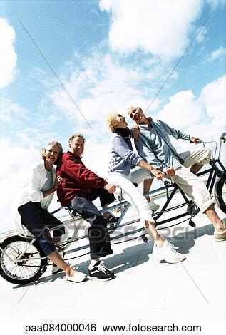 Mature couples on tandem bike at beach, portrait. View Large Photo Image Stock Photograph - Mature couples on tandem bike at beach, portrait.. Fotosearch