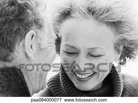 Stock Photo - Mature man looking at smiling mature woman, close-up, portrait, B&W.. Fotosearch
