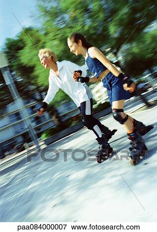 Stock Photo - Mature woman and girl in-line skating, blurred.. Fotosearch